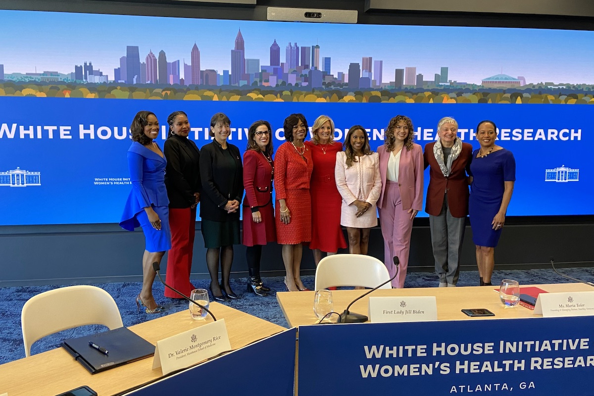Round table attendees stand with first lady Jill Biden